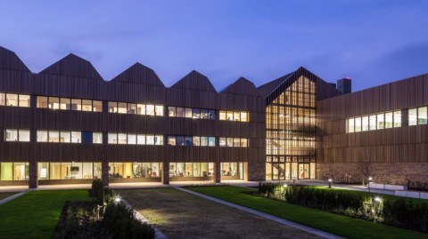 Night time view of building covered in wooden slatted panels